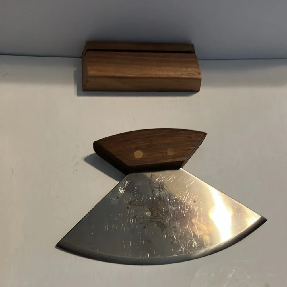 Alaskan Ulu knife with a walnut wood handle and‎ a stand.