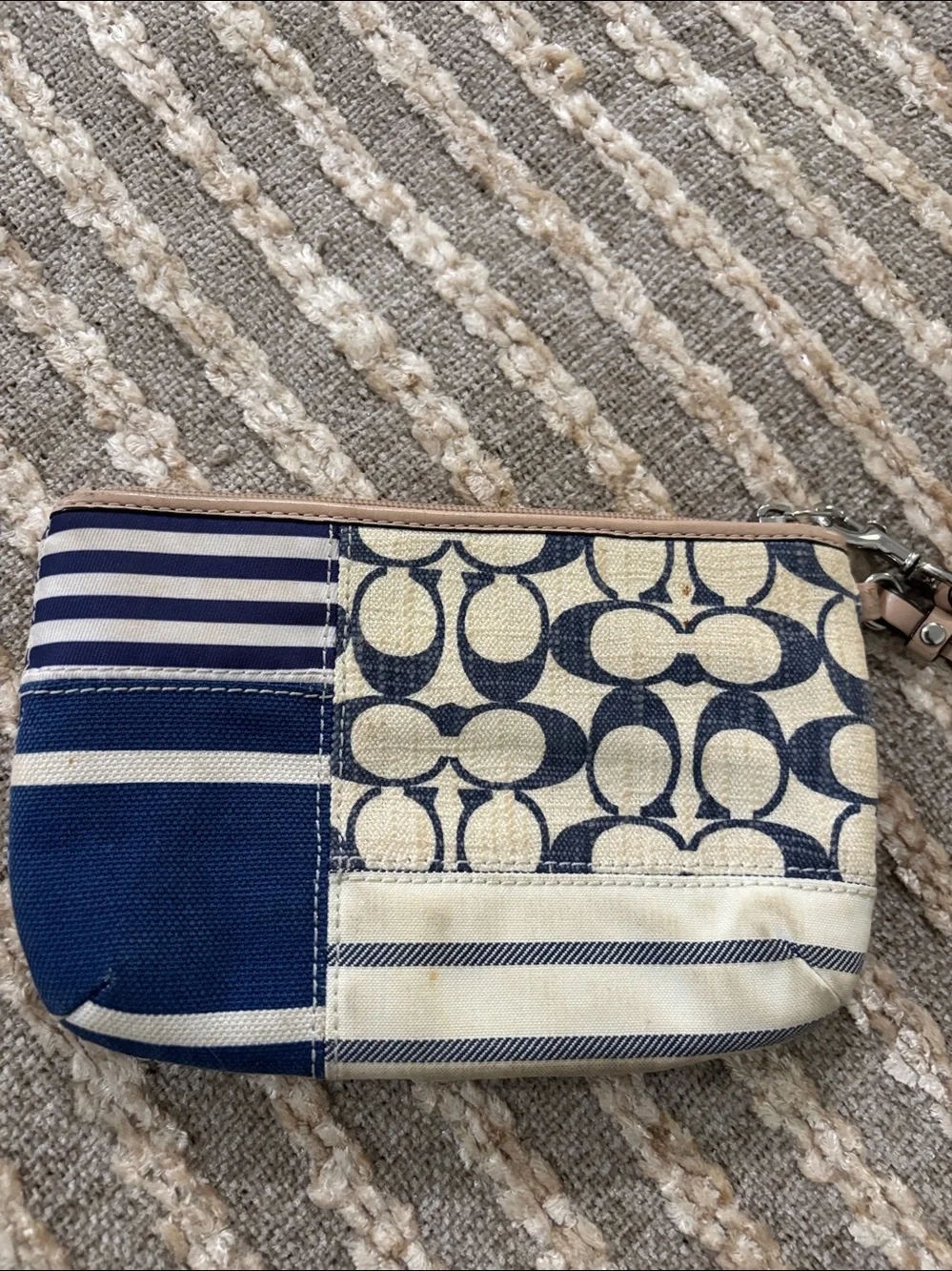 Coach wristlet featuring signature patchwork print in navy and cream