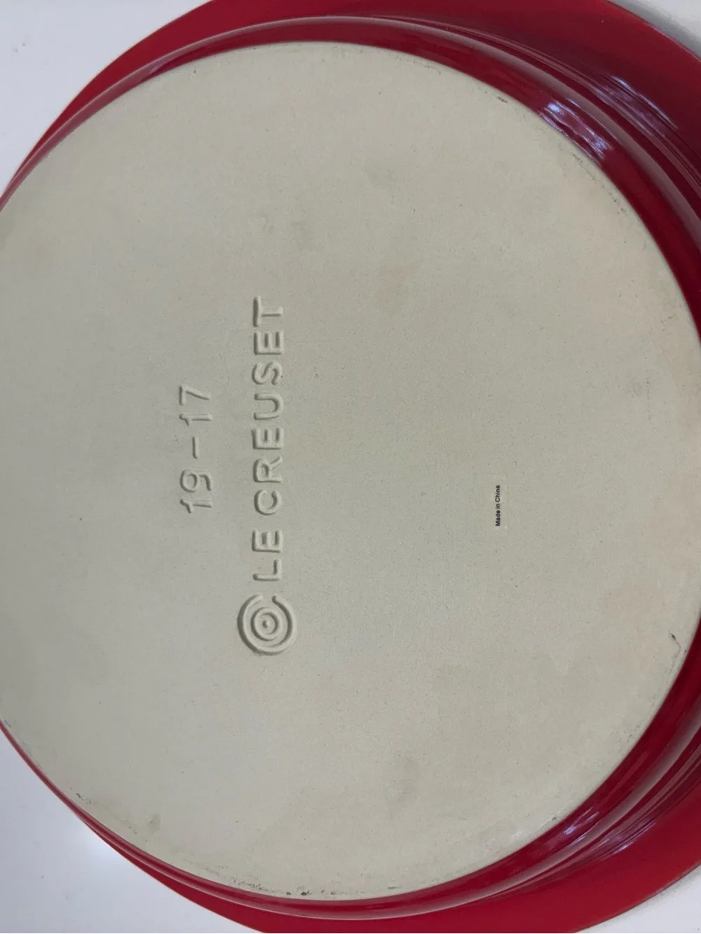 Le Creuset Cerise Red pie baking dish featuring a cream-colored interior.