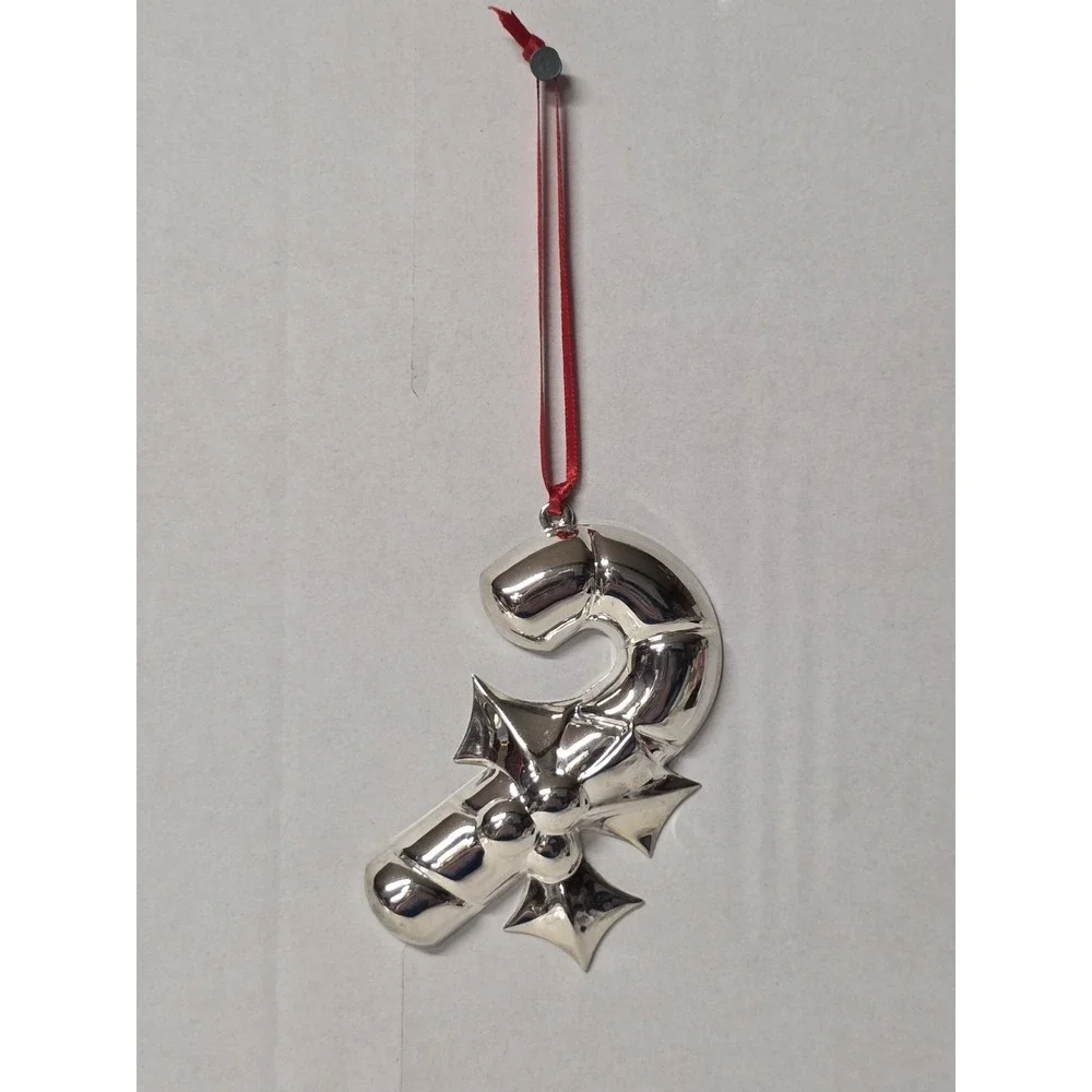 silver-plated Christmas ornament shaped like a candy cane with a holly design