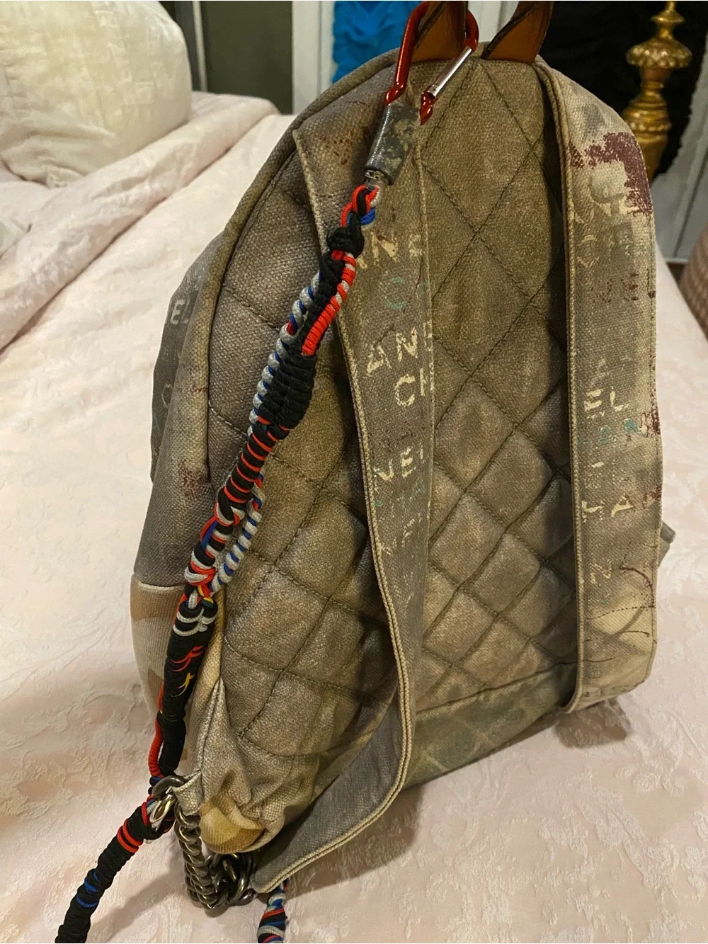 CHANEL Faded Beige Canvas Backpack with Multicolor Strap and Silver-Tone Charm