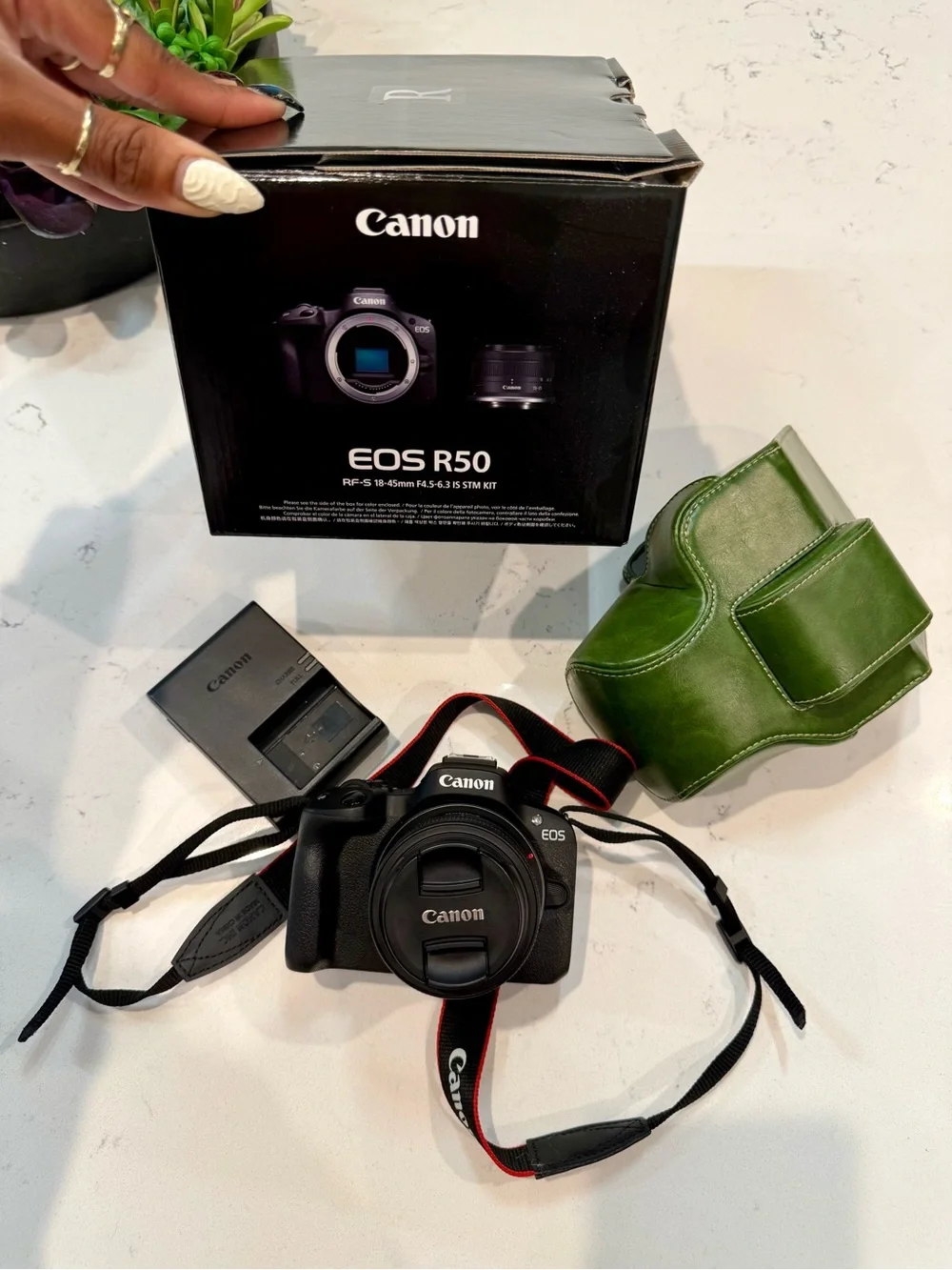 Canon EOS R50 Black Mirrorless Camera with Red-Trim Strap and Green Case